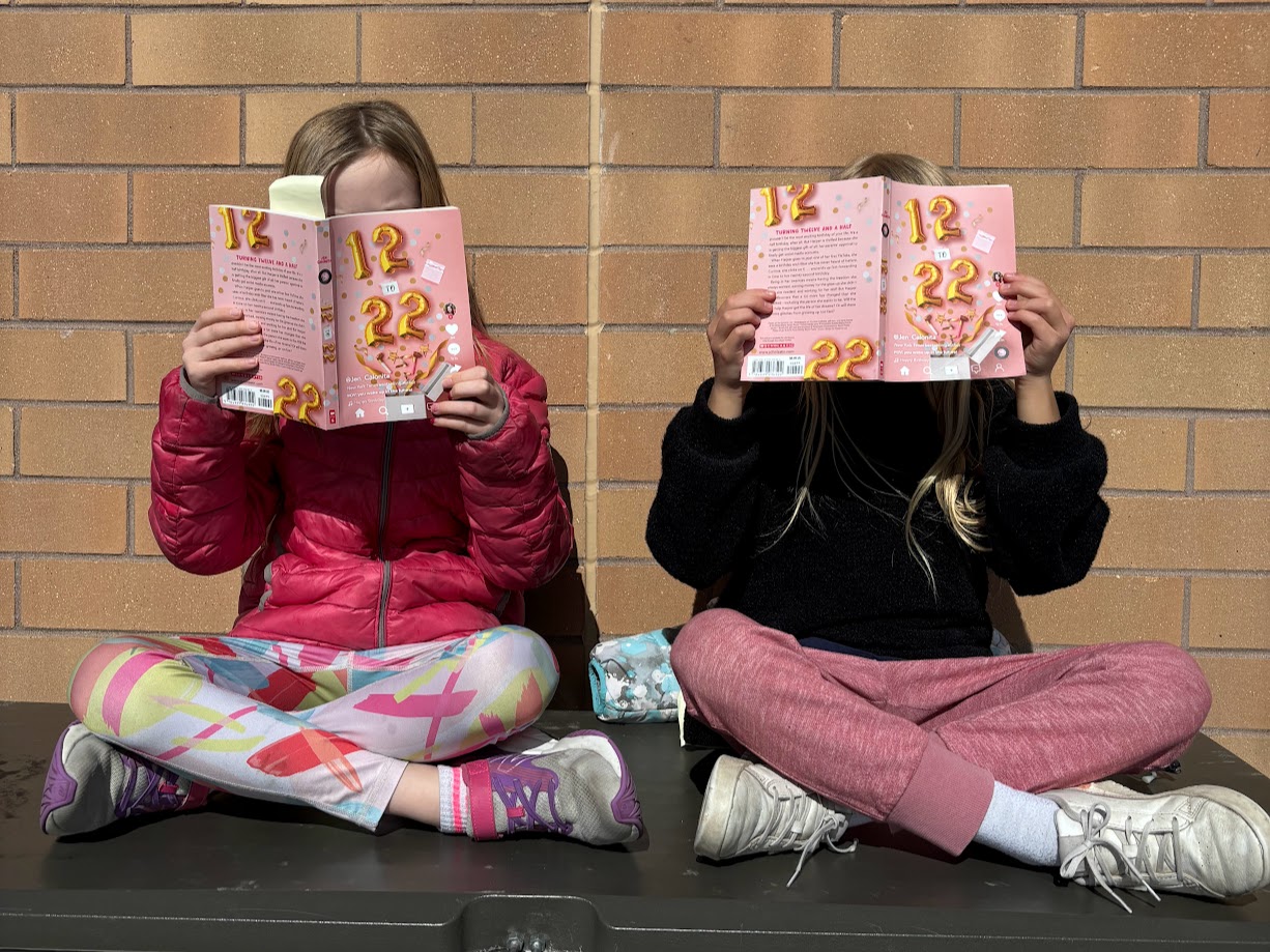 Two students holding up books